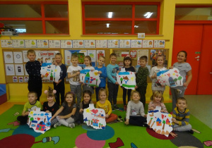 Grupa dzieci pozuje do zdjęcia z siedmioma szablonami mapy Polski.
